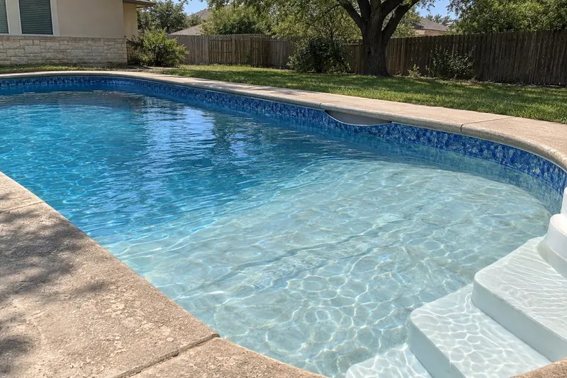 Faded vinyl pool liner pulling out of its track below the deck