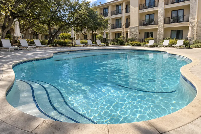 Hotel pool with a light finish and dark stripes on bench and step edges