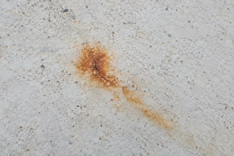 Rust stain bleeding through white pool plaster from the steel below