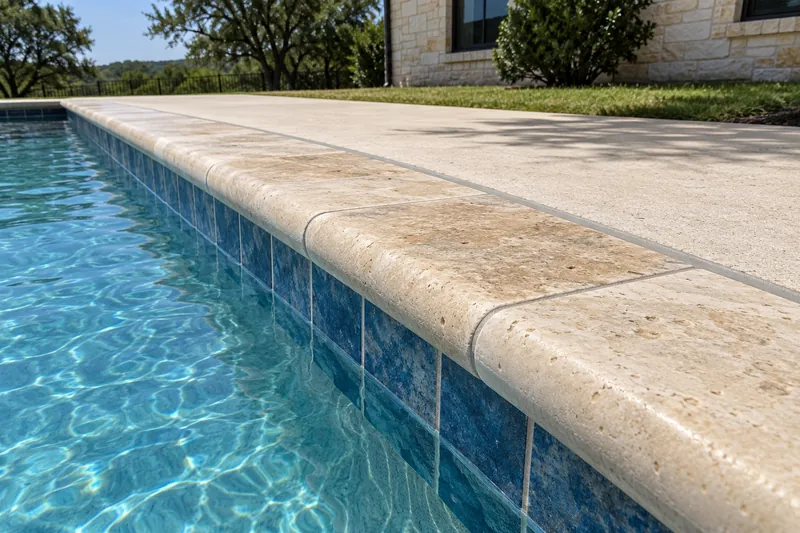 Travertine bullnose pool coping with a sealed joint to the deck
